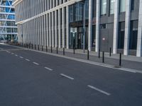 the empty street with bicycles parked in front of the buildings has a sign that says the library on it