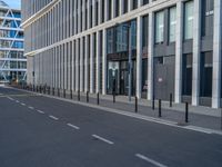 the empty street with bicycles parked in front of the buildings has a sign that says the library on it