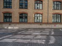 a brick courtyard has steps leading up to it, and a blue umbrella is on the ground