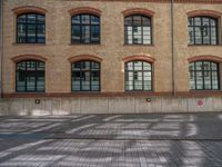 a brick courtyard has steps leading up to it, and a blue umbrella is on the ground