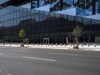 an empty road with trees and some building in the background of the picture in front