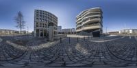 a view from an outside of a circular building with buildings and a sky background with no clouds