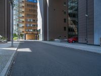 a road through which is a large modern building with an awning over it's entrance