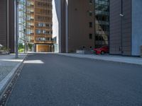 a road through which is a large modern building with an awning over it's entrance