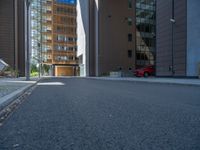 a road through which is a large modern building with an awning over it's entrance