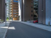 a road through which is a large modern building with an awning over it's entrance