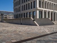 the large office building is located in the center of a cobblestone plaza of the city