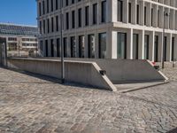 the large office building is located in the center of a cobblestone plaza of the city