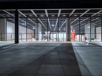 a view of a large open space with concrete flooring and windows and lights on