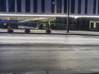 a blue car driving by a building with a street light on it at night in london