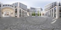 a panorama lens is reflected on a circular stone courtyard in a business area with skyscrapers