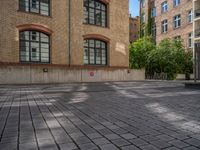 a brick courtyard has steps leading up to it, and a blue umbrella is on the ground