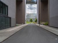 a long paved street with a building in the background and tall buildings outside each, both showing doors