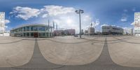 a fisheye lens view of three buildings and sky in the background taken with one of the lens panes wide