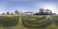 an image of the view of the campus from the grass field with a building in the background