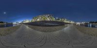 a 360 - up view of an urban scene of buildings near water with lights on