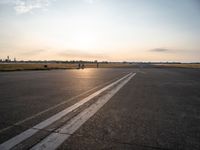 the airplane is parked near the runway ready to take off from the airport runway at sunset