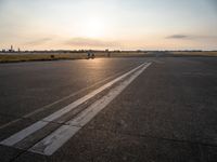 the airplane is parked near the runway ready to take off from the airport runway at sunset