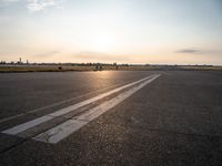 the airplane is parked near the runway ready to take off from the airport runway at sunset