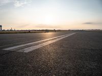 the airplane is parked near the runway ready to take off from the airport runway at sunset