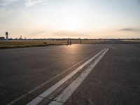 the airplane is parked near the runway ready to take off from the airport runway at sunset