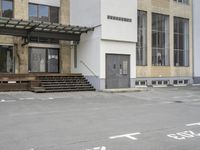 an empty building with signs on the street and people on bikes in traffic passing by