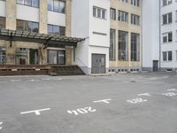 an empty building with signs on the street and people on bikes in traffic passing by