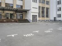 an empty building with signs on the street and people on bikes in traffic passing by