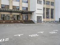 an empty building with signs on the street and people on bikes in traffic passing by