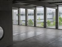 an empty building with doors that lead to a courtyard area, with some trees in the foreground