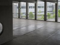 an empty building with doors that lead to a courtyard area, with some trees in the foreground