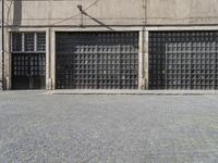 a person with a backpack is standing in front of a building on a cobblestone street