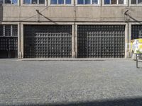 a person with a backpack is standing in front of a building on a cobblestone street