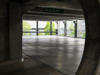 the ground is littered with gray tiles and signs on it is dark, empty, with trees in the background