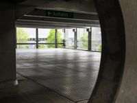 the ground is littered with gray tiles and signs on it is dark, empty, with trees in the background