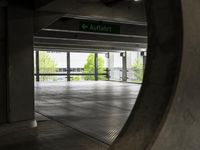 the ground is littered with gray tiles and signs on it is dark, empty, with trees in the background