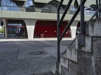 a building with glass windows and some steps outside it that has an umbrella in front