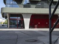 a building with glass windows and some steps outside it that has an umbrella in front