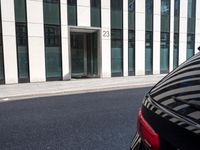 a black skateboard is standing in the middle of the street in front of a building