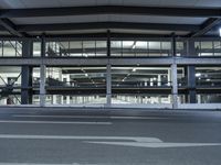 an empty city street with some large windows above it, and some stairs in the background