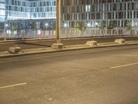 a couple of empty parking benches in the street near a building with tall glass windows