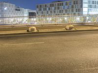 a couple of empty parking benches in the street near a building with tall glass windows