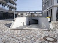 a street with the entrance to a tunnel for pedestrians to walk under on top of it