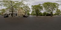 a 360 - view panoramic photograph shows a street, buildings and cars on the road