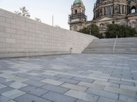 there is a skateboard that is on the steps near an elaborate building and a statue