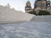 there is a skateboard that is on the steps near an elaborate building and a statue