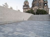 there is a skateboard that is on the steps near an elaborate building and a statue