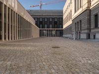 a view of the empty courtyard of a building with some pillars in the foreground