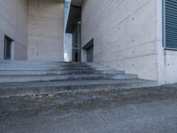 concrete staircase up to a large building with a clock tower in the middle of it