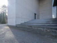 concrete staircase up to a large building with a clock tower in the middle of it